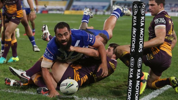 Gymnastic move: Sam Kasiano of the Bulldogs gets across the line at ANZ Stadium.