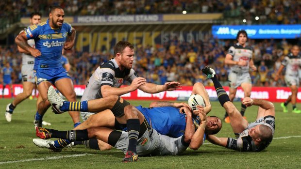 Getting there: Brad Takairangi scores for the Parramatta Eels despite the defence of the North Queensland Cowboys at Pirtek Stadium.