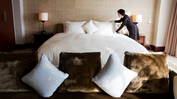 An employee arranges a bed inside a royal suite room at the Hotel Lotte Co. Seoul hotel in South Korea.