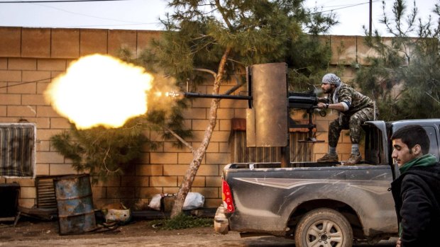 A YPG fighter fires an anti-aircraft weapon towards Islamic State militants in Tel Tamr.