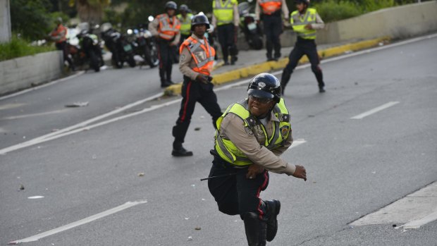 A Police officer confronts protesters, not pictured, in Caracas on Thursday.