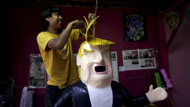 A worker hangs a pinata depicting US Republican presidential candidate Donald Trump at a workshop in Reynosa, Mexico.