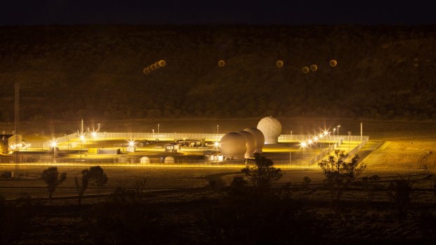 Among the satellite antennas, the lights of Pine Gap multiply in the camera lenses at night.