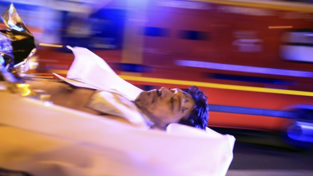 A man is evacuated from the Bataclan after the shooting.