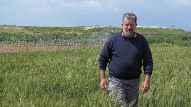 Pablo Leffler stands in the farmlands of Kibbutz Ein HaShlosha. The structures and razor wire behind him surround of the Hamas tunnels discovered by the Israel Defence Forces last year.