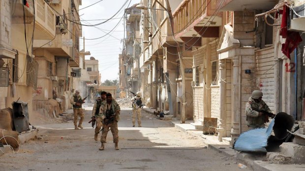 Syrian government soldiers patrol a street in the ancient city of Palmyra, central Syria, in March.
