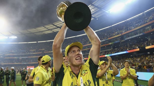 Man of the match James Faulkner celebrates with the World Cup trophy on Sunday. 