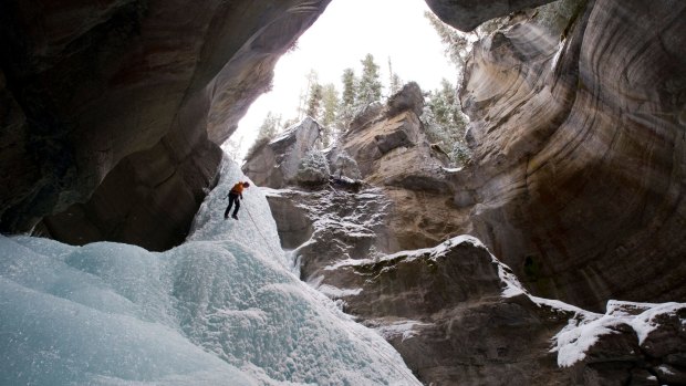 Ice climber rappels into the head of Maligne Canyon in Jasper National Park, Alberta, Canada.