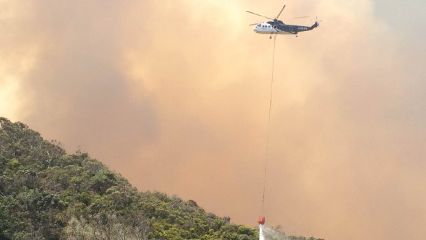 A helicopter tackles the blaze that destroyed numerous homes in the Wye River fire on Christmas Day.