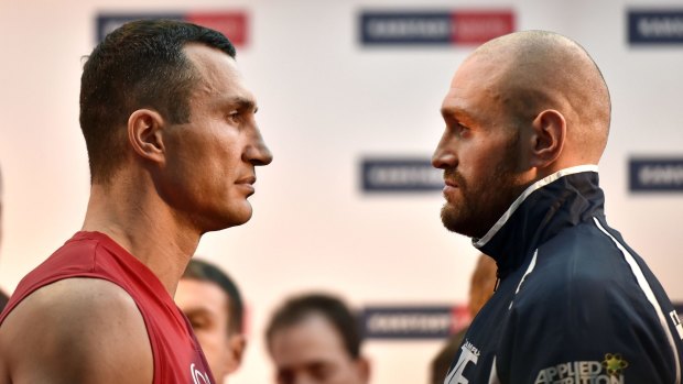 Face off: Challenger Tyson Fury watches world champion Wladimir Klitschko, left, after the weigh-in.