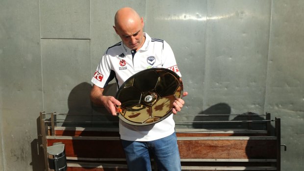 Kevin Muscat admires the A-League trophy, something he would surely like to win again next season.