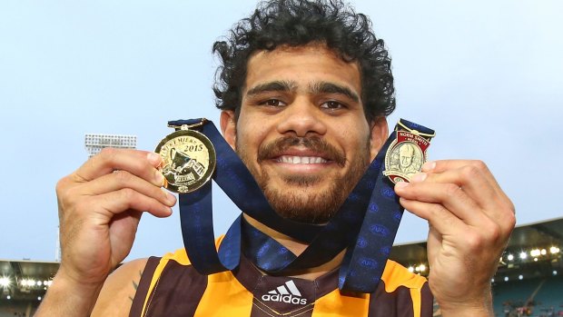 Cyril Rioli celebrates with his premiership medal and the Norm Smith Medal.