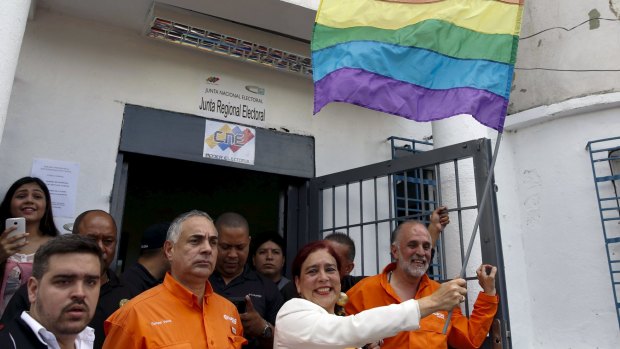 Tamara Adrian, holds a LGBT flag as she arrives to register her candidacy for the upcoming parliamentary elections.
