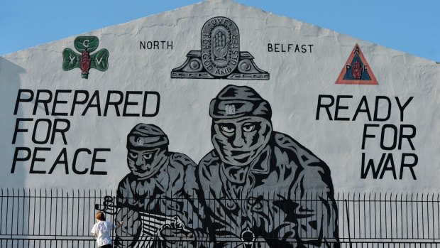 A young boy plays near a loyalist paramilitary mural in Belfast.