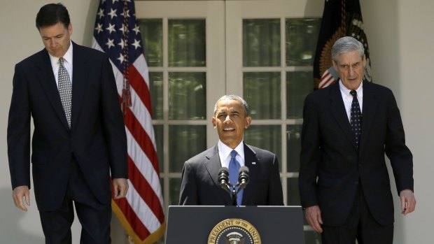 At six foot, eight inches, James Comey, left, towers over Robert Mueller, right, as they stand behind then President Barack Obama in 2013. 