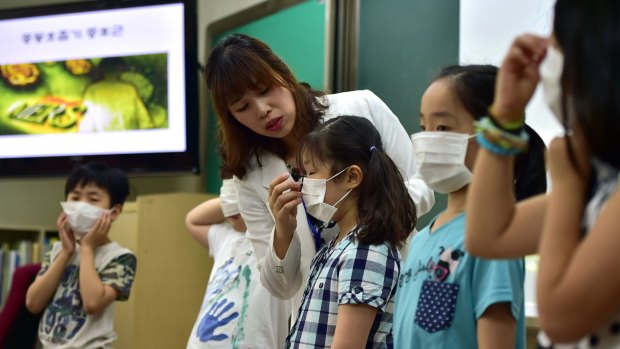 South Korean school students put on face masks during a special class on MERS.
