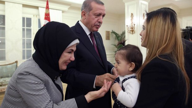 Turkish President Recep Tayyip Erdogan and his wife, Emine, greet the freed hostages.