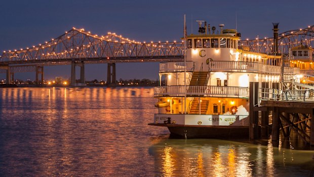 A riverboat on the Mississippi River in New Orleans at dusk.