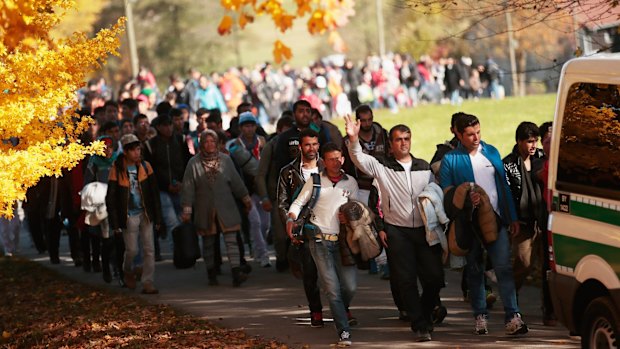 German police lead arriving refugees from Wegsheid, near the Austrian border to a transport facility on Wednesday.