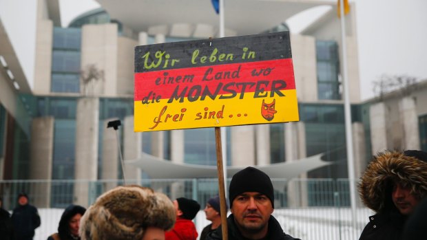 The 'International Convention of German Russians' protest against sexual assaults by migrants in Berlin. The sign reads "We live in a country where monsters are free".  The girl whose claims sparked this protest later admitted fabricating her story of rape by Middle Eastern-looking men.