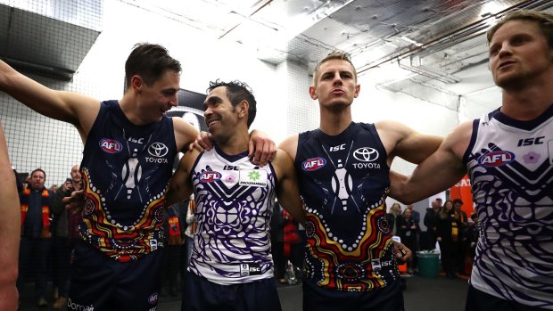 Eddie Betts and Rory Sloane sing the Crows song in the Dockers' Indigenous jumpers. 