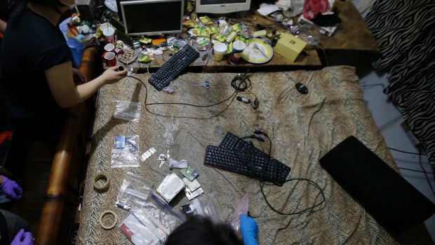Members of the Philippines' National Bureau of Investigation and the FBI gather evidence at Deakin's residence. Authorities have since arrested three women who were livestreaming sexually exploitative videos of girls to men paying by the minute to watch from countries including Australia.