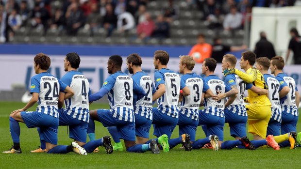 Solidarity: Hertha BSC Berlin kneel prior to their clash with FC Schalke.