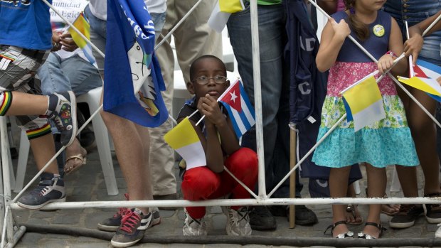 A boy tries to get a glimpse of Pope Francis from behind a fence in Havana on Sunday.