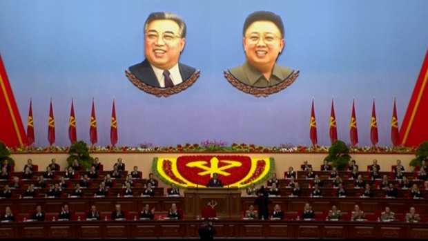 North Korean leader Kim Jong-un, centre, in front of portraits of his father and grandfather.