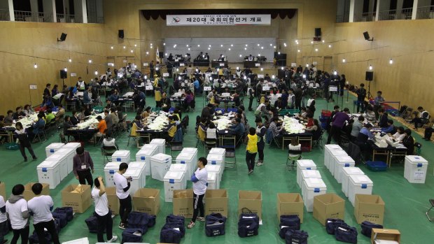 South Korean National Election Commission officials sort out ballots start the counting in Seoul on Wednesday.
