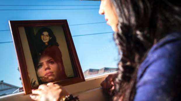 Tanille Mizzi's face is reflected in a photograph of her mother Samantha, who  was murdered in 1994.