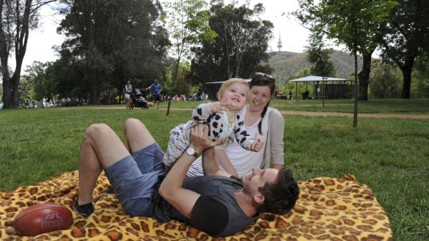 Clair and Jake Gumley of Banks with one-year-old Penelope enjoy the sunshine in front of the new shelters and BBQ area in upgraded Weston Park. 