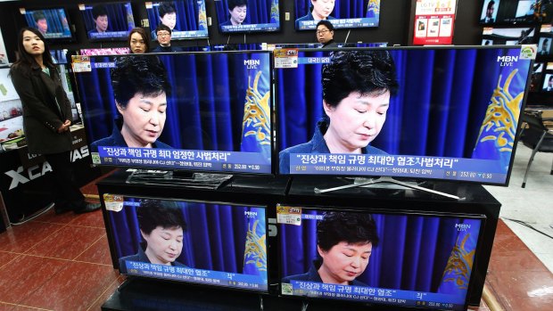 TV screens show the moment Park Geun-hye took sole blame for a "heartbreaking" scandal that threatens her government.