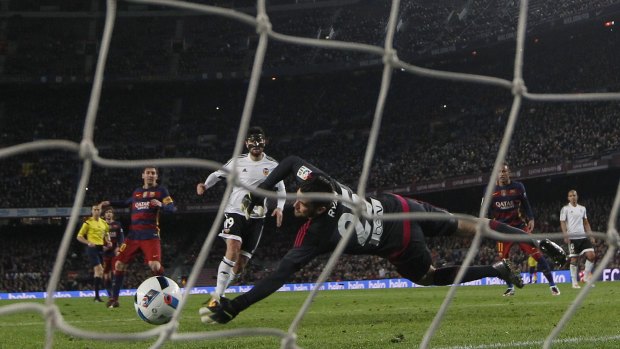 FC Barcelona's Lionel Messi scores against Valencia's goalkeeper Mathew Ryan.