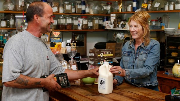 Popular choice: Mick Kir, owner of Upper Gully Organics shop and his shop manager Jenni Duncan with some bottles of Mountain View Organic Dairy Bath Milk, which he sells at his shop.