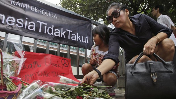 A woman lays flower outside the Starbucks cafe where Thursday's attack took place in Jakarta.