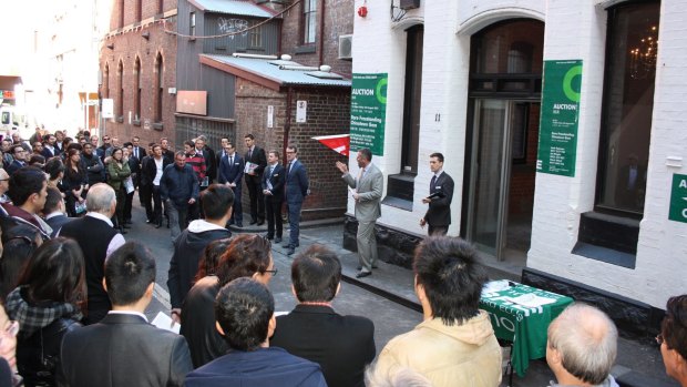 A huge crowd gathers for a Melbourne CBD auction of retail and office premises.