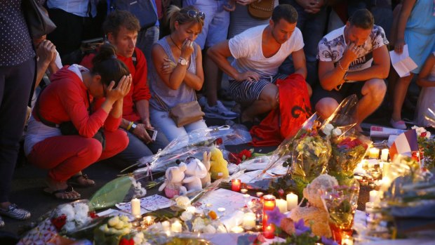 People pay homage to the victims at a makeshift memorial in Nice.