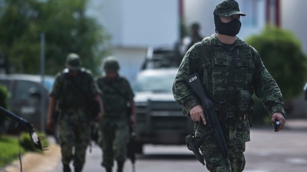 Soldiers leave a private gated community hours after a military convoy was ambushed with grenades and high-powered guns in Culiacan, Mexico, on Friday.