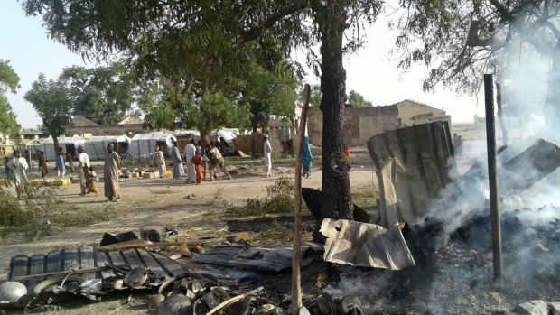 In this image supplied by the aid group Medecins Sans Frontieres, smoke rises from a burnt-out shelter at a camp for displaced people in Rann, Nigeria. 