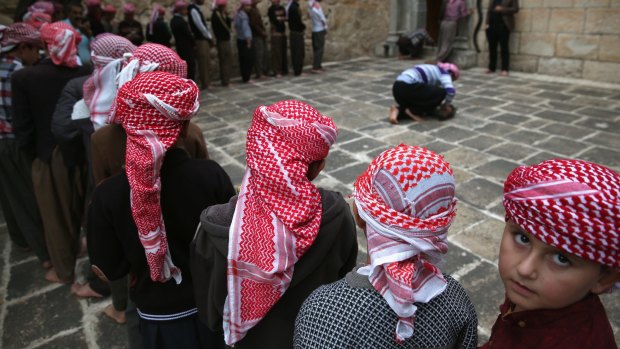 Yazidi boys line up to pray at their religion's most holy temple on November 6, in Lalish, Iraq. Many Yazidi visitors to the Lalish temple were displaced from Sinjar Mountain, overrun by IS in 2014, when IS killed thousands of the men and enslaved many Yazidi women. 