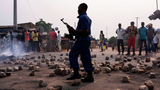 A Burundian policeman walks through rubble during protests against the governing party in June last year. Burundi came last on the 2016 list of happiest countries in the world.