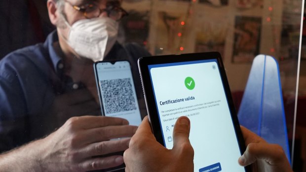 A customer has his "green pass" checked at the entrance of a cinema in Milan, Italy on Friday.