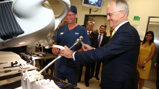 Prime Minister Malcolm Turnbull looks at a hip joint replacement robot during a hospital visit.