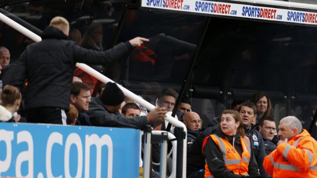 Newcastle manager John Carver (right) is surrounded by security staff as he remonstrates with a fan.