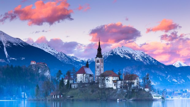 Sunset view of Julian Alps, Lake Bled with St. Marys Church of the Assumption on the small island.