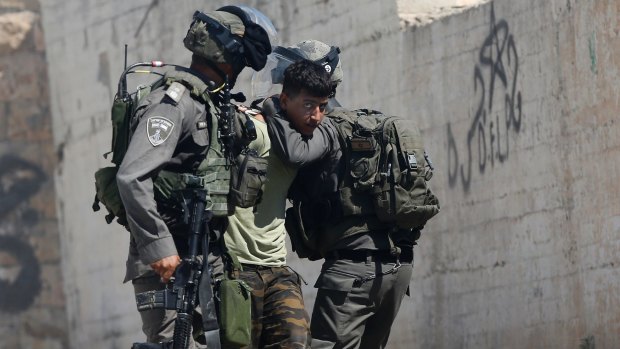 Israeli border police arrest a Palestinian  in the occupied West Bank village of Deir Abu Mashal  on Saturday.