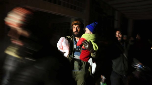 A man and child are evacuated as the UN voted to send monitors into Aleppo. 