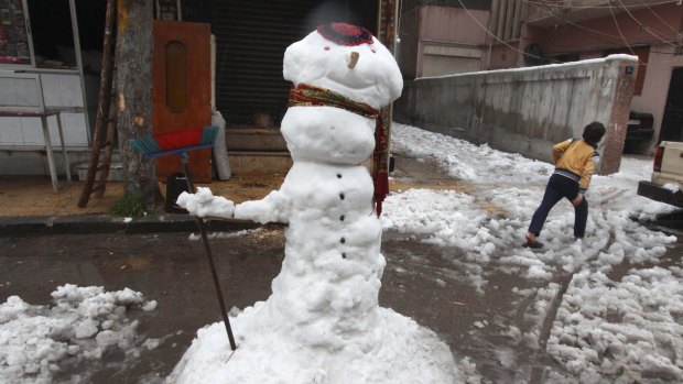 A snowman stands on the streets of Damascus, Syria, following storms that hit the Middle East.
