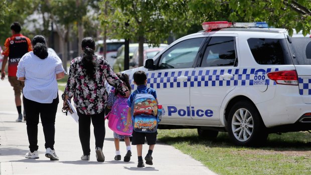 Parents take their children from a primary school in Melbourne's north, following an evacuation after a bomb threat.